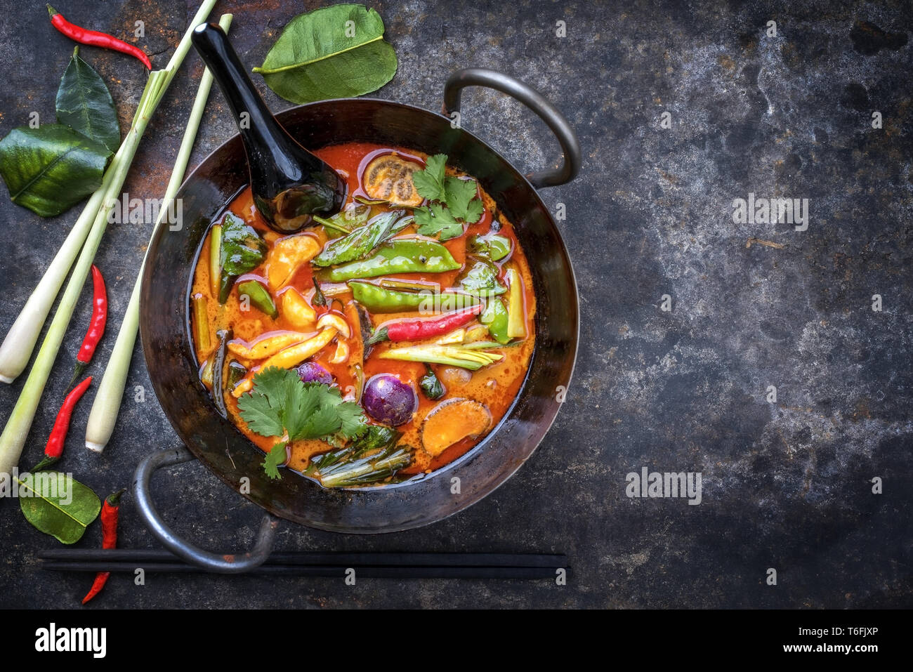 Traditional Thai kaeng phet red curry with vegetables as top view in a wok with copy space right Stock Photo