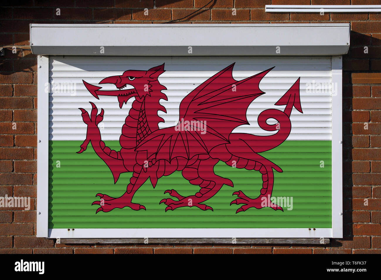 Wales flag on closed security shutters Stock Photo