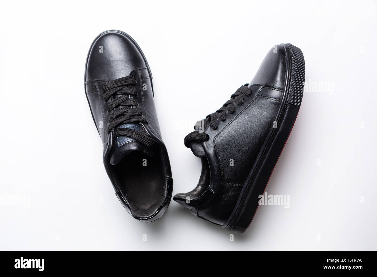 a pair of black fashion sneakers with black laces on a white background ...
