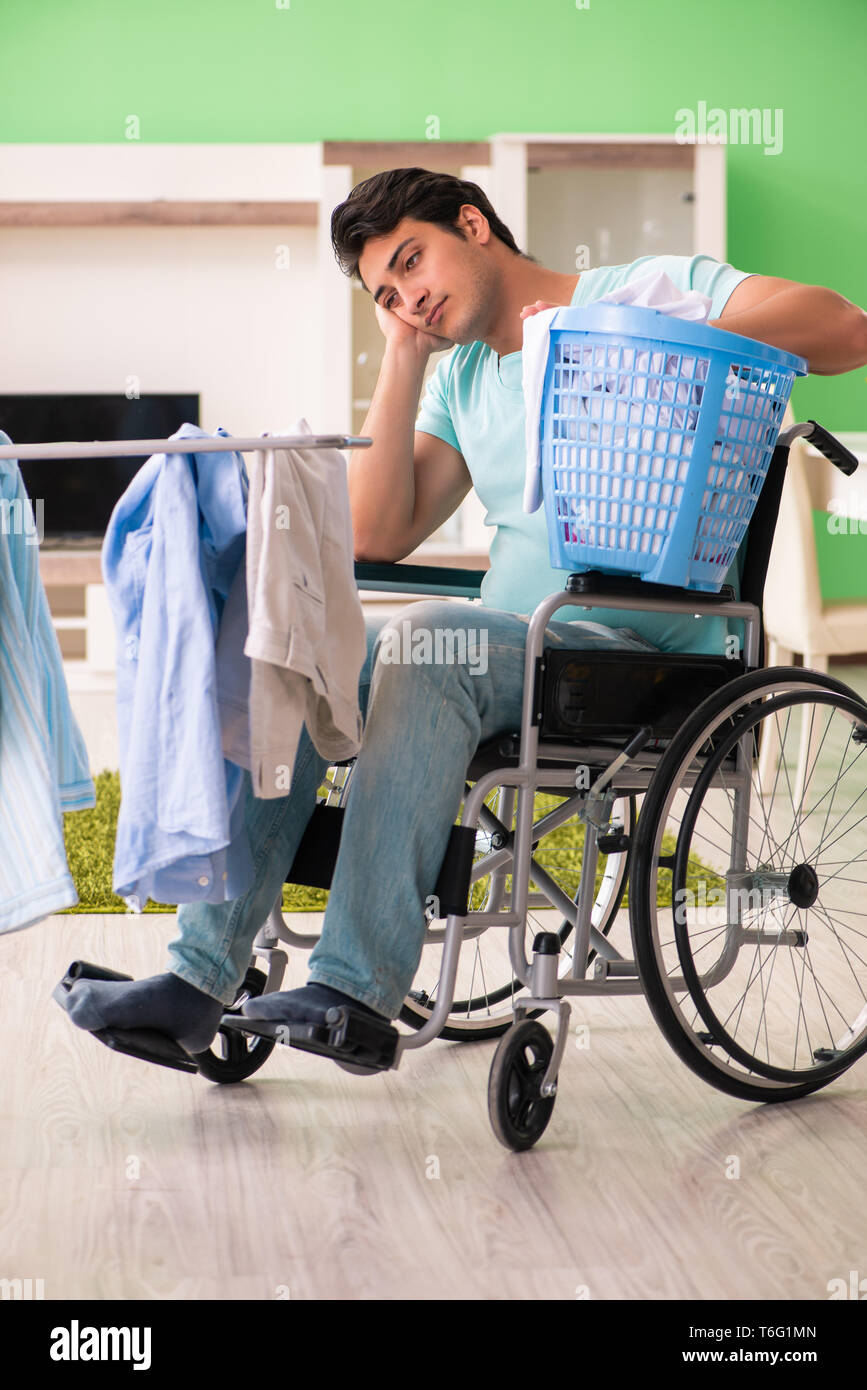 Disabled man on wheelchair doing laundry Stock Photo