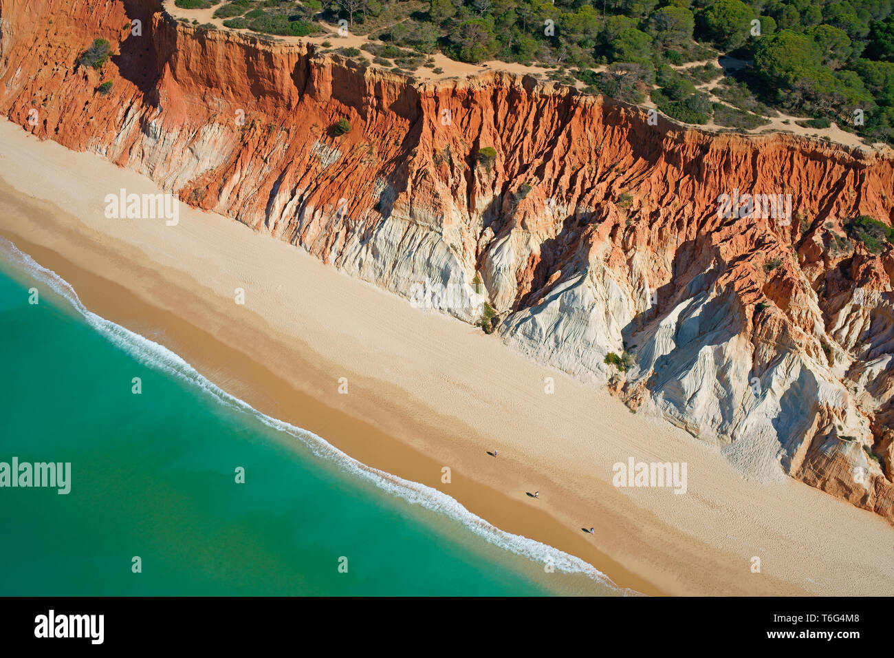 AERIAL VIEW. Praia da Falésia (beach of the cliff); an eroded seaside cliff with multicolored strata. Albufeira, Algarve, Portugal. Stock Photo