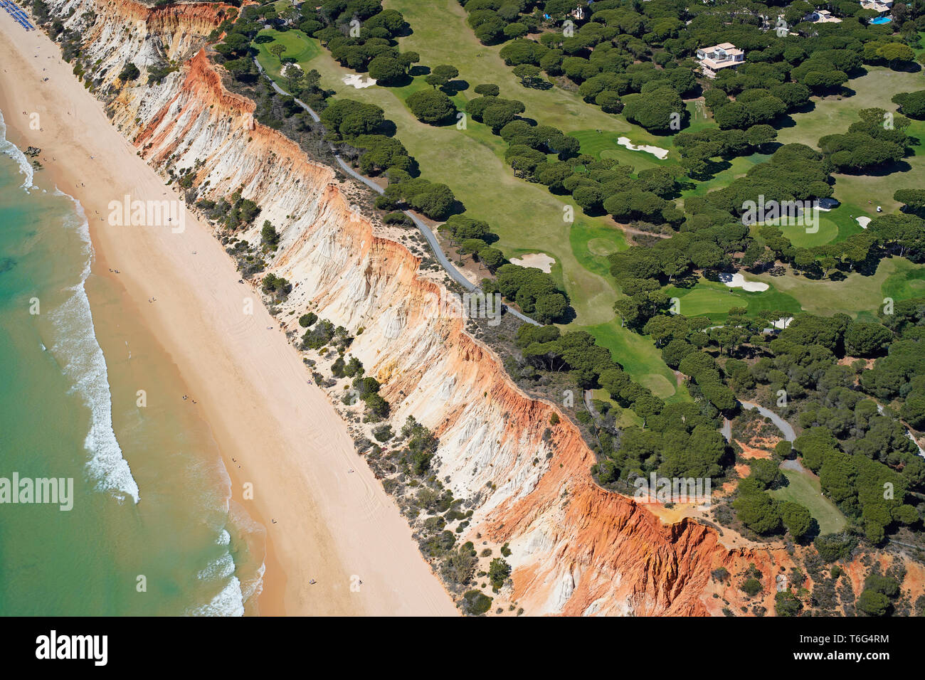 AERIAL VIEW. Pine Cliffs Golf Course overlooking the scenic beach of Praia da Falésia alongside the Atlantic coast. Albufeira, Algarve, Portugal. Stock Photo