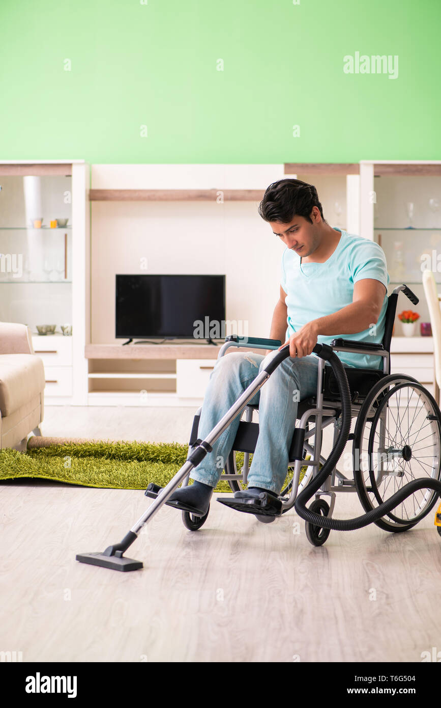 Disabled man on wheelchair vacuum cleaning house Stock Photo Alamy