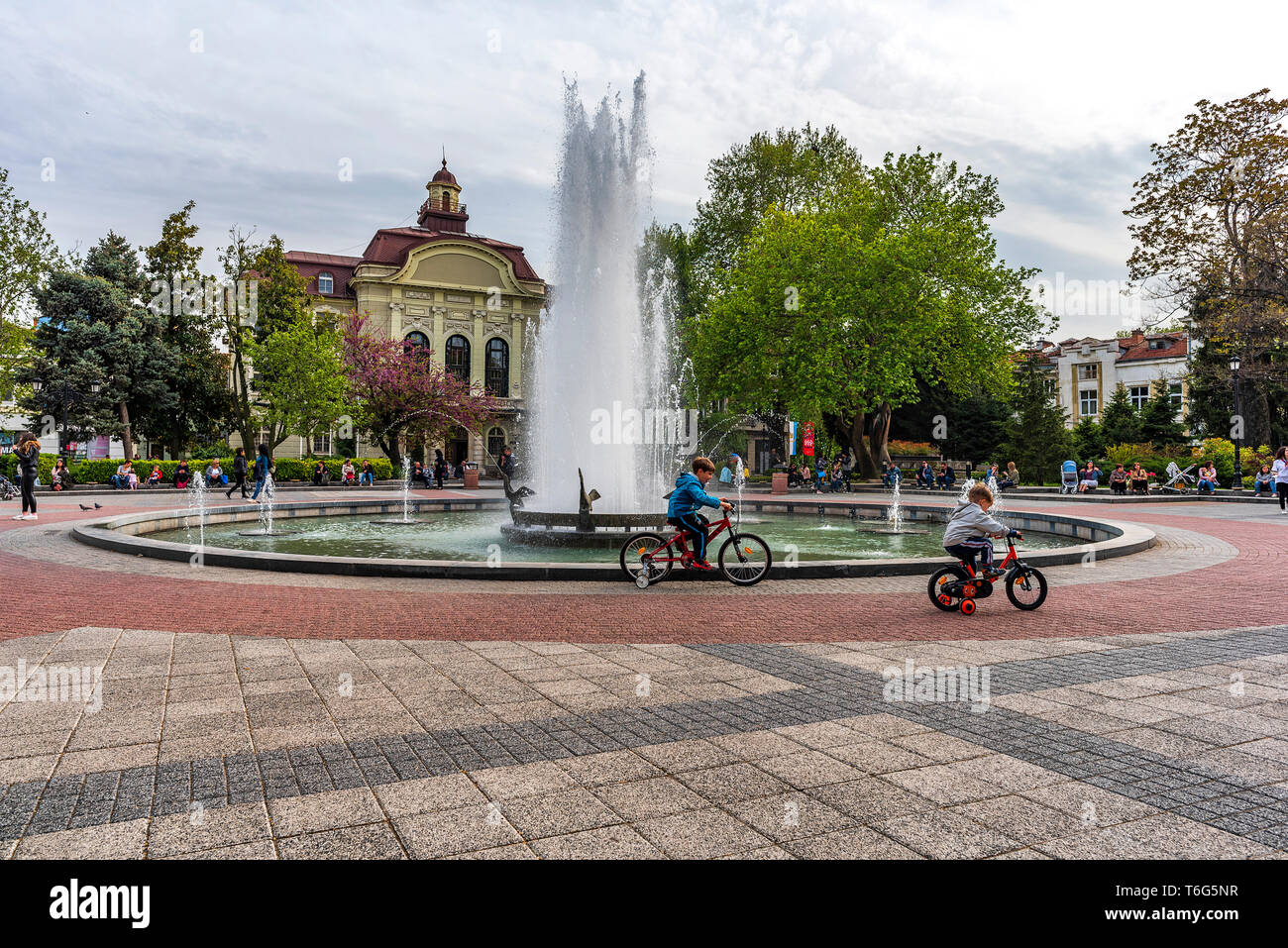 People around fountain on Stefan Stambolov square in center of Plovdiv city. Spring time. Stock Photo
