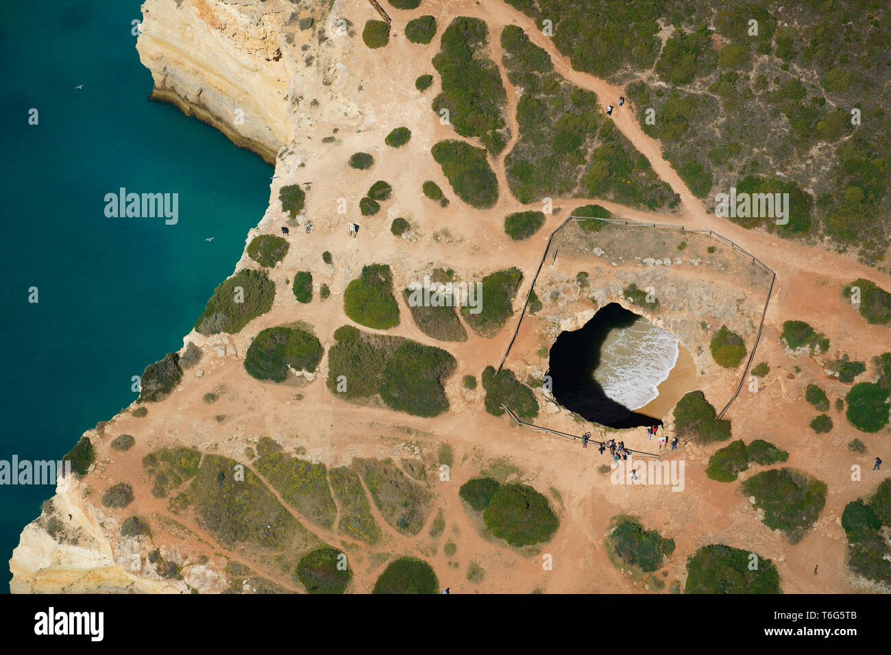 AERIAL VIEW. Algar de Benagil: a large photogenic sea cave on the jagged coastline of the Algarve coast. Lagoa, Portugal. Stock Photo