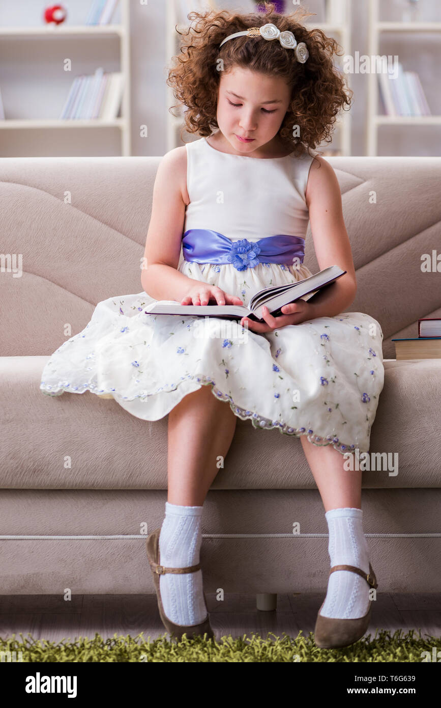 Little pretty girl reading books at home Stock Photo - Alamy