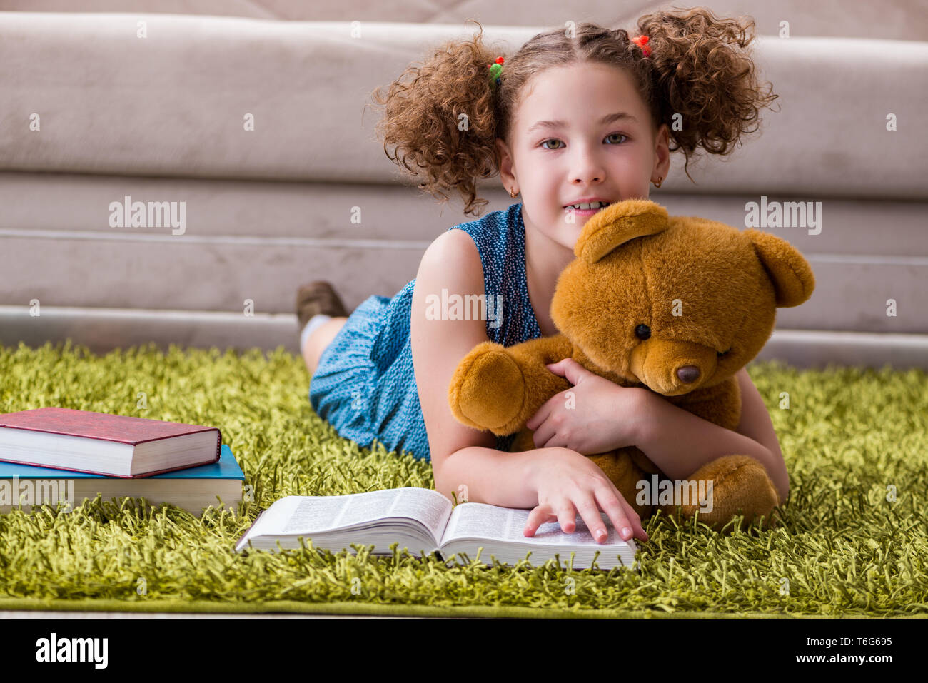 Little pretty girl reading books at home Stock Photo - Alamy
