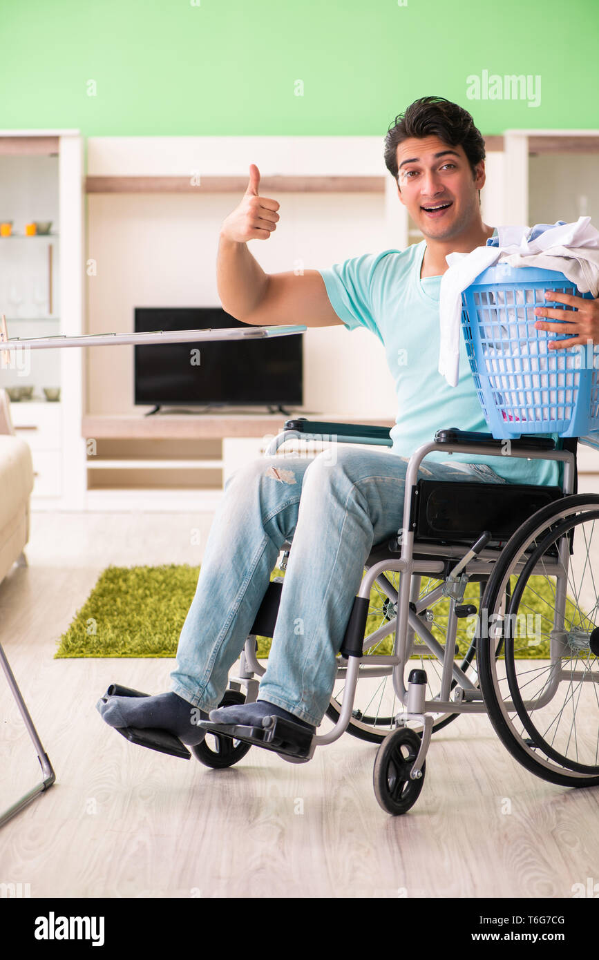 Disabled man on wheelchair doing laundry Stock Photo