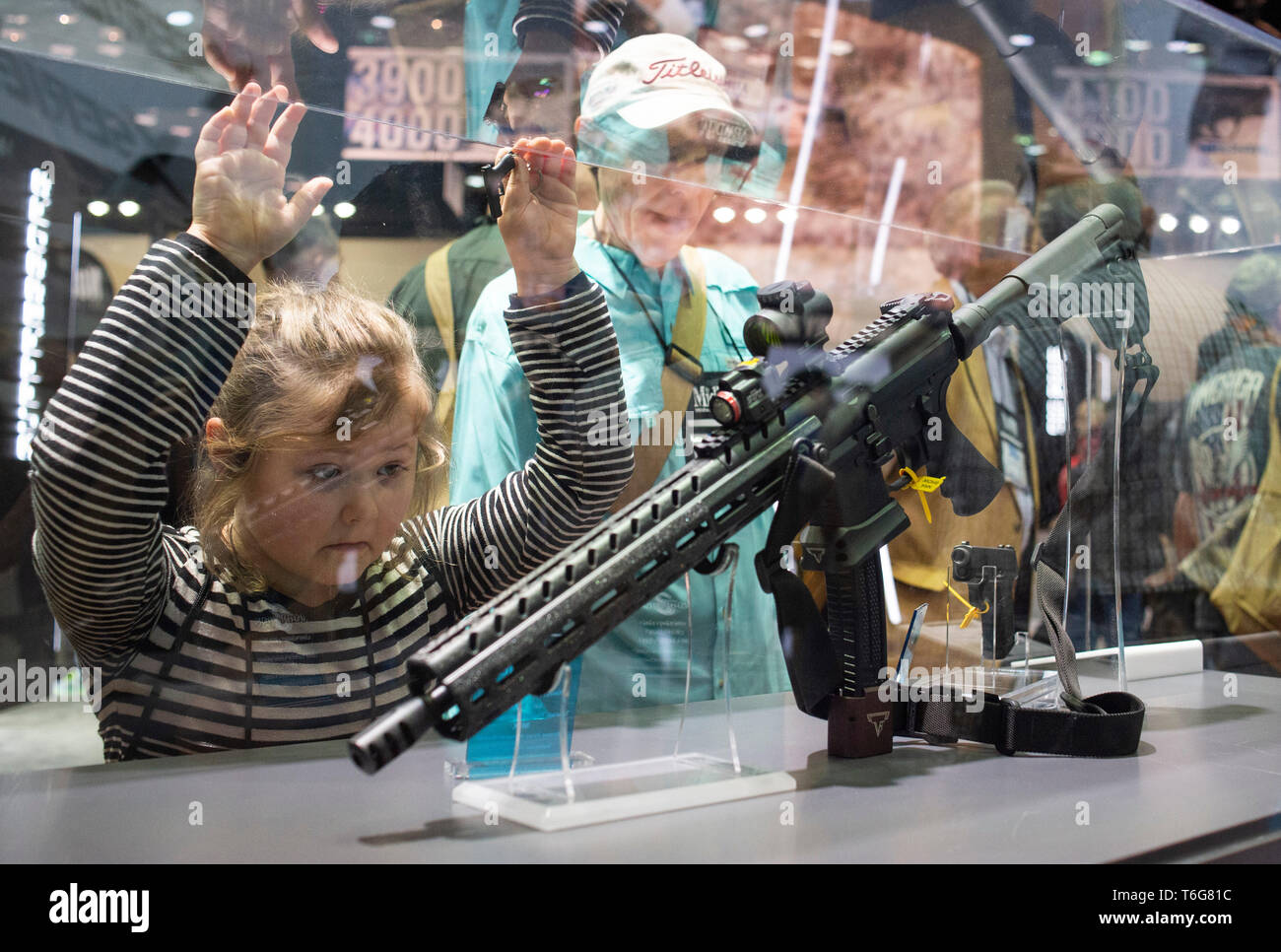A young girl seen admiring a weapon by Sig Saur that will be featured in  the upcoming John Wick film during an exhibition. NRA members and leaders  gather in Indianapolis, Indiana for