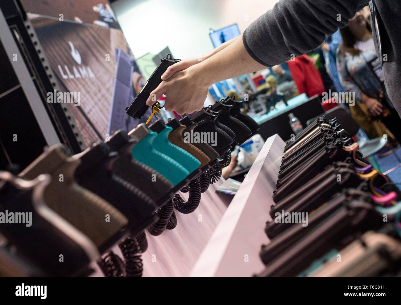 NRA members are seen checking out weapons and accessories during an exhibition. NRA members and leaders gather in Indianapolis, Indiana for the annual NRA Meeting where President Donald Trump and others spoke and attendees were able to view a multitude of exhibits featuring firearms, outdoors equipment, and shooting gear. Stock Photo