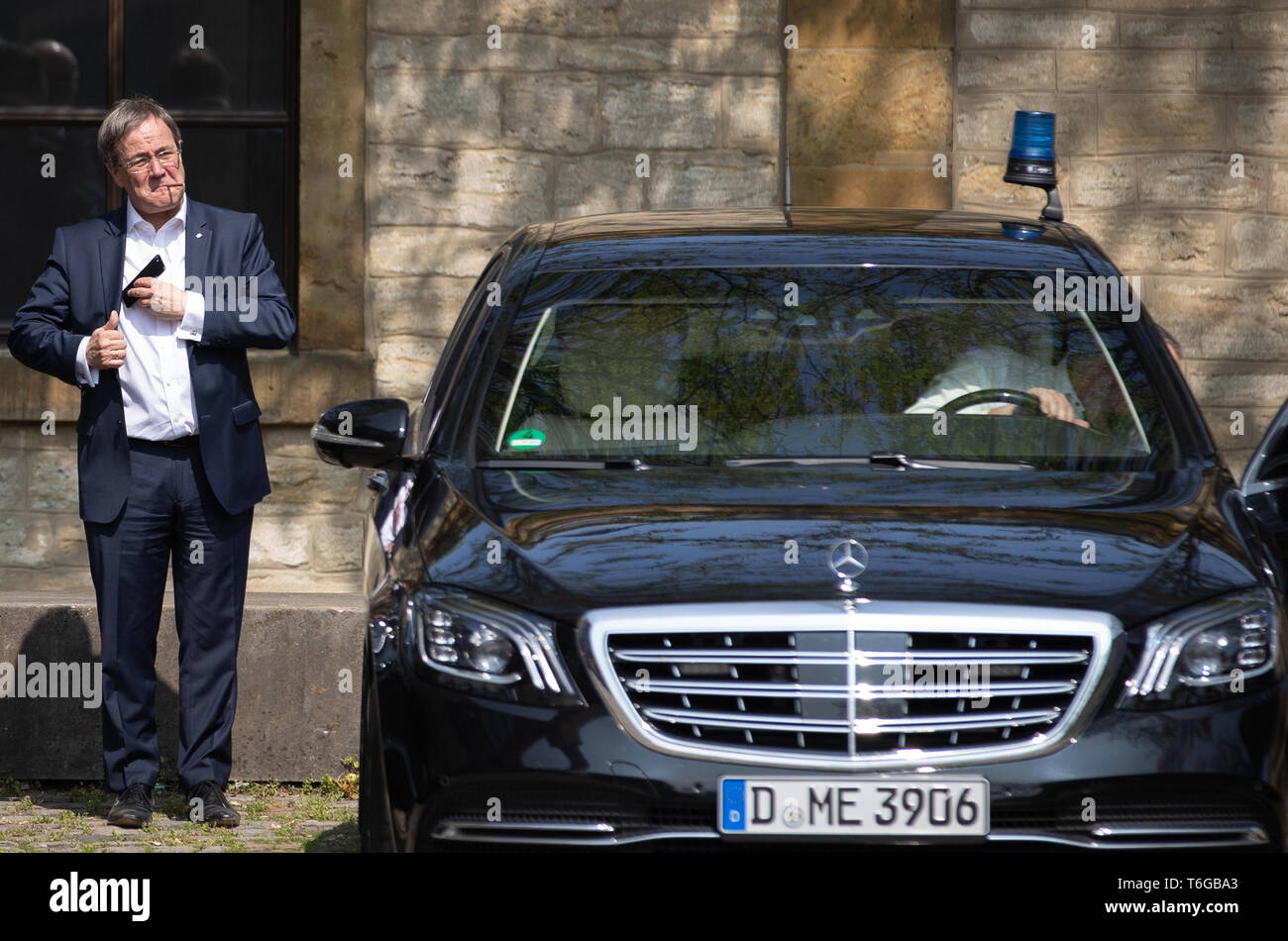 Bielefeld, Germany. 01st May, 2019. NRW Prime Minister Armin Laschet (CDU)  stands next to a company car and smokes while he puts his mobile phone in  his jacket on "Labour Day" after