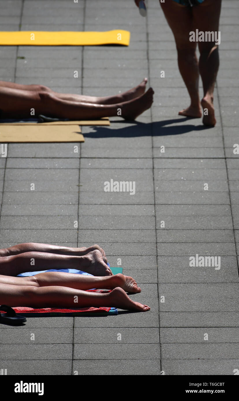 Landsberg Am Lech, Germany. 01st May, 2019. Swimmers enjoy the sunshine at the edge of the swimming pool in the Landsberger Inselbad. The bath traditionally opens the bathing season on 1 May. Credit: Karl-Josef Hildenbrand/dpa/Alamy Live News Stock Photo