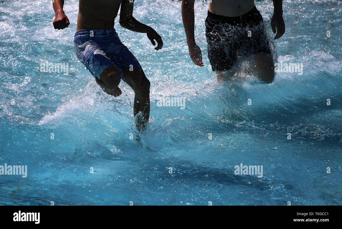 Landsberg Am Lech, Germany. 01st May, 2019. Young men run through the surf of the wave pool. The Landsberg Inselbad traditionally opens its bathing season on 1 May. Credit: Karl-Josef Hildenbrand/dpa/Alamy Live News Stock Photo