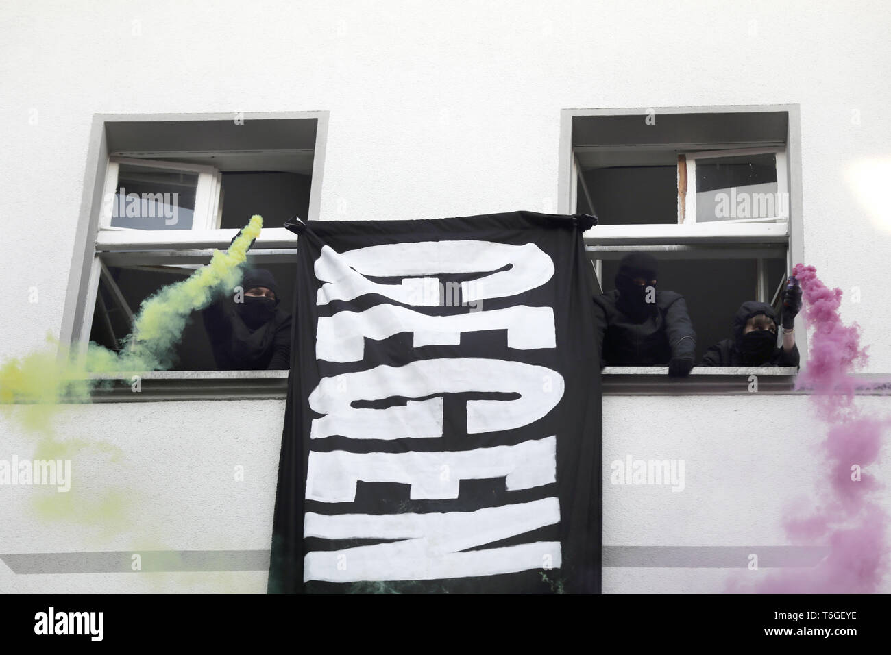 Berlin, Germany. 01st May, 2019. Sympathisers of the left-wing radical 'Revolutionaries 1 May Demonstration' keep pyrotechnics out of a window. Credit: Kay Nietfeld/dpa/Alamy Live News Stock Photo