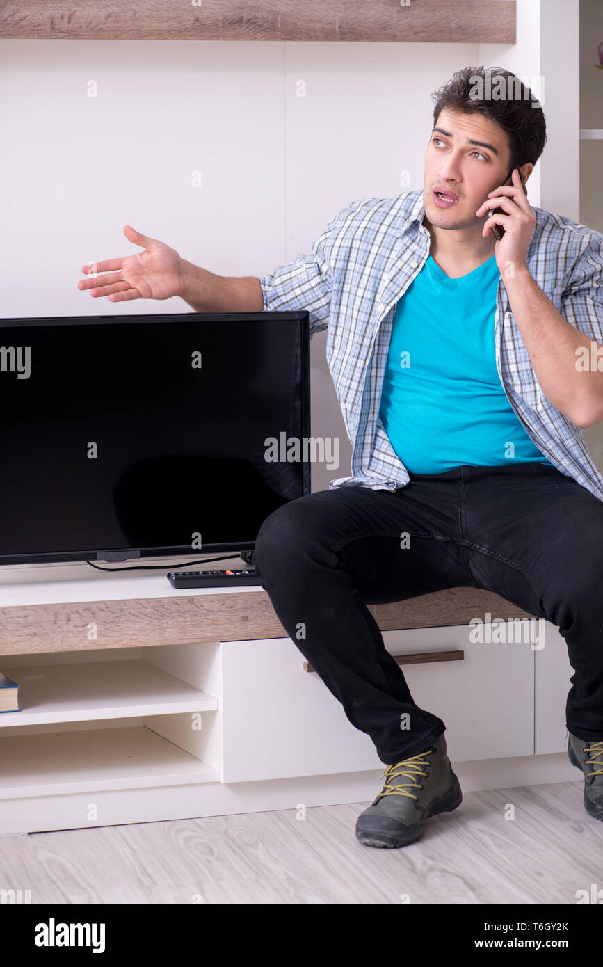 Man trying to fix broken tv Stock Photo Alamy