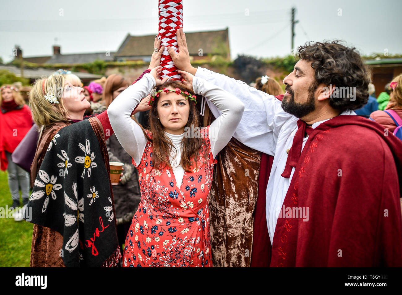 People touch the maypole during the Beltane celebrations at Glastonbury Chalice Well, where
