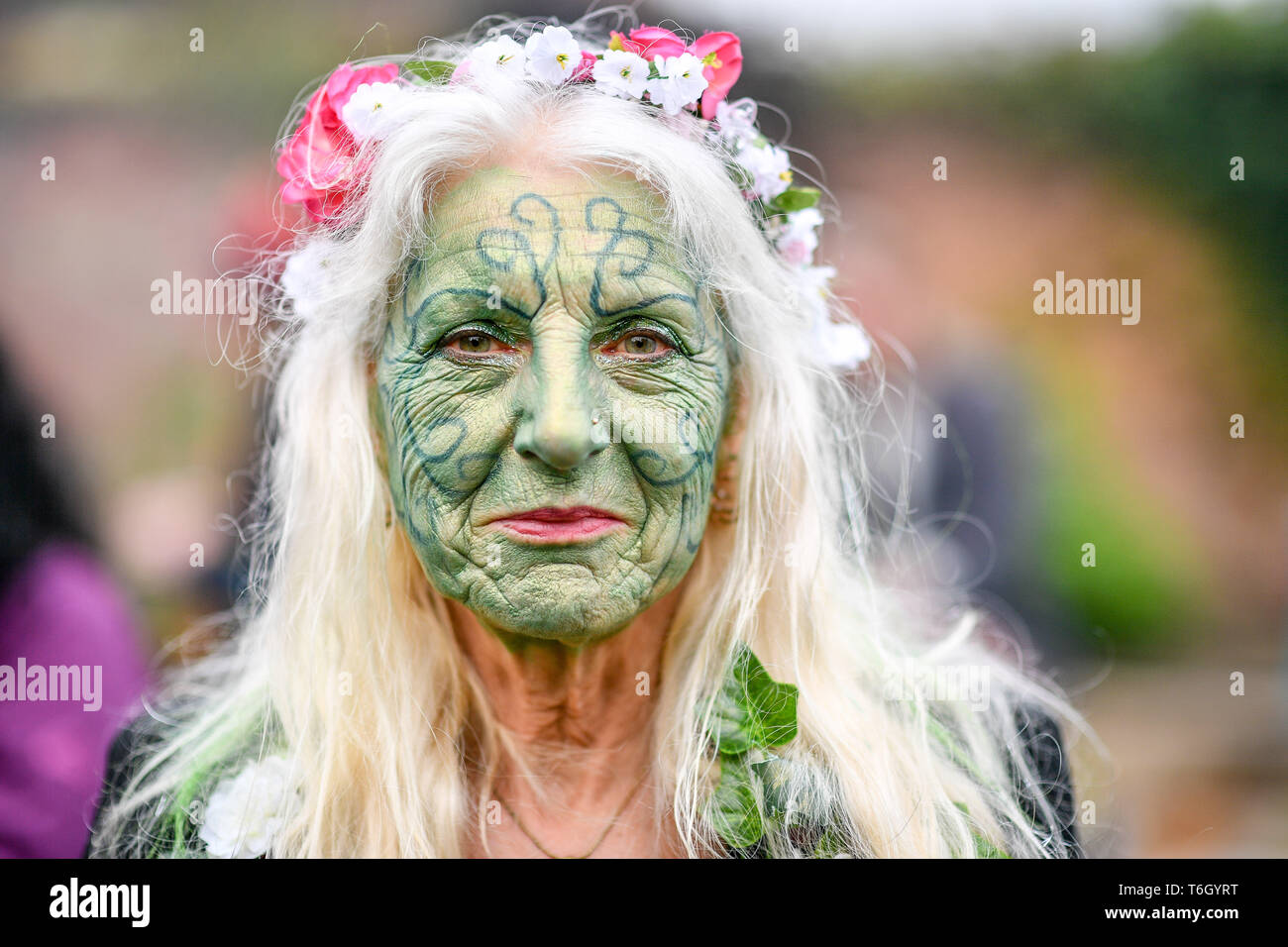 Glastonbury Border Morris Jean Growney wears green face paint during the Beltane celebrations at Glastonbury Chalice Well, where people gather to observe a modern interpretation of the ancient Celtic pagan fertility rite of Spring. Stock Photo