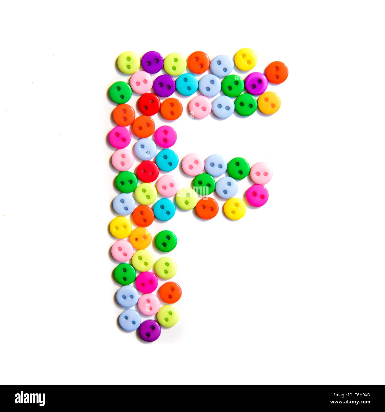 Letter F of the English alphabet from a group of colorful small buttons on a white background Stock Photo