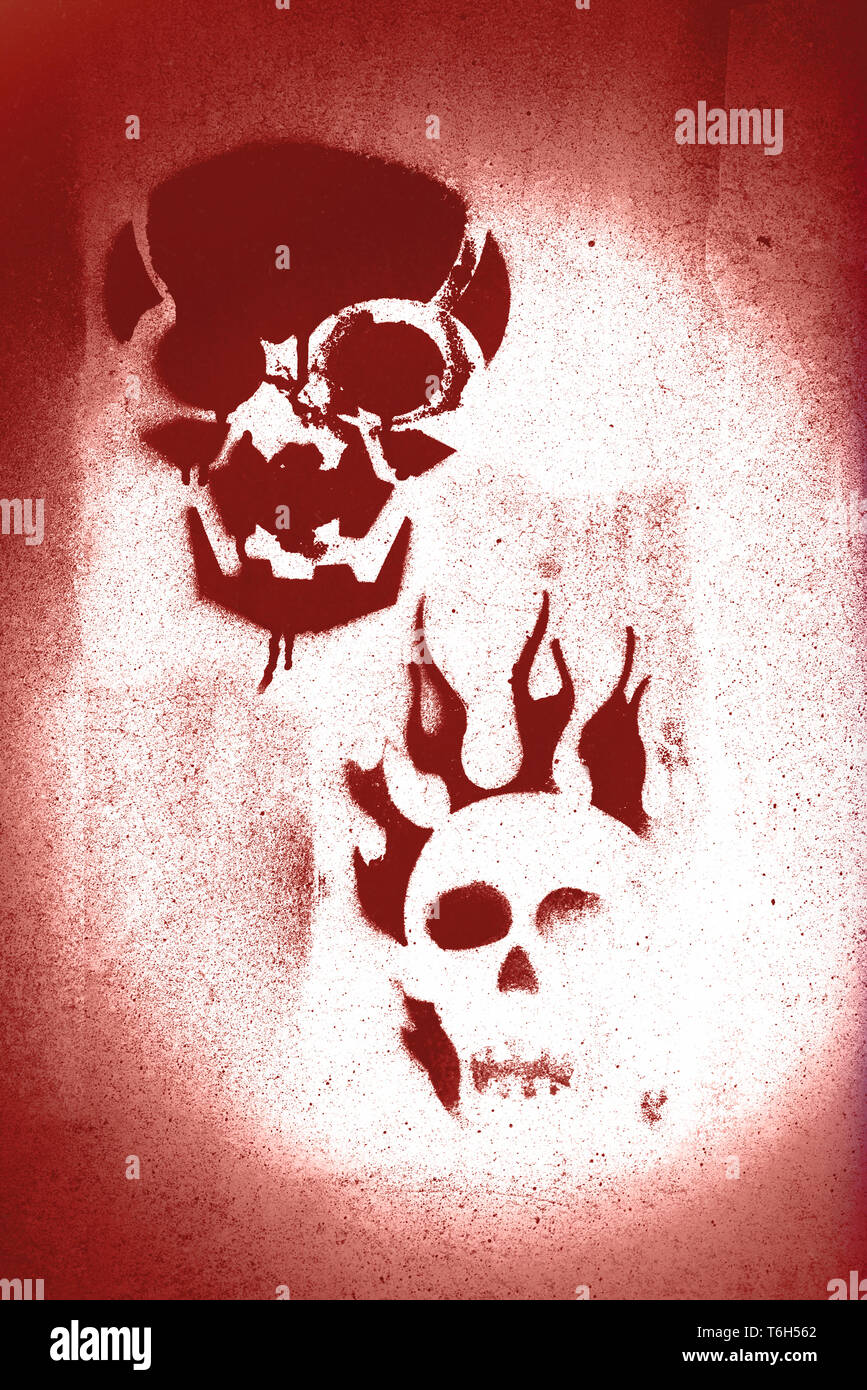 Two skulls in red spray painted on concrete Stock Photo