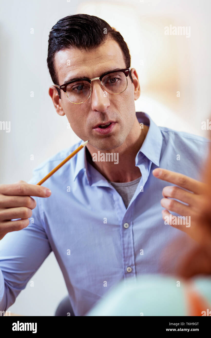 Serious handsome young man holding a pencil Stock Photo