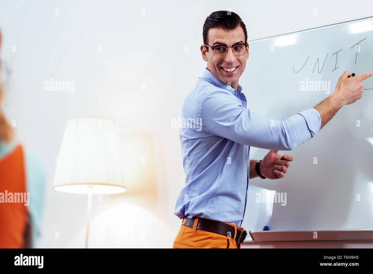 Joyful professional teacher smiling to his student Stock Photo