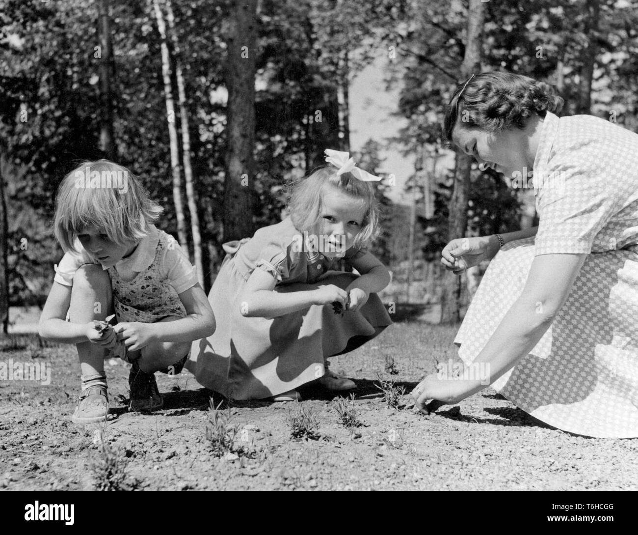 1950s day care. Two children and a woman is playing outdoors at a nursery school. Sweden 1953 Stock Photo