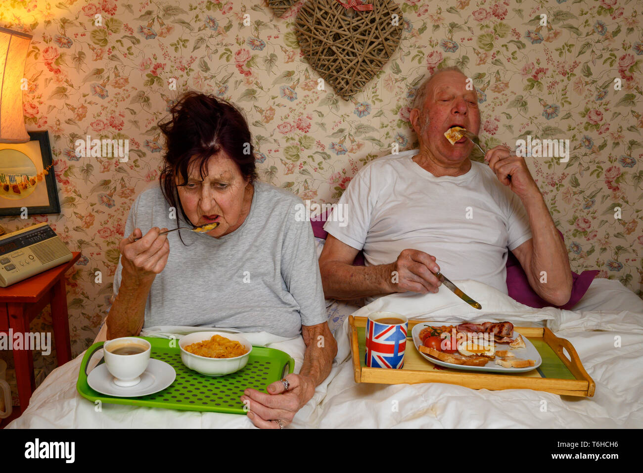 Elderly couple eating breakfast in bed Stock Photo