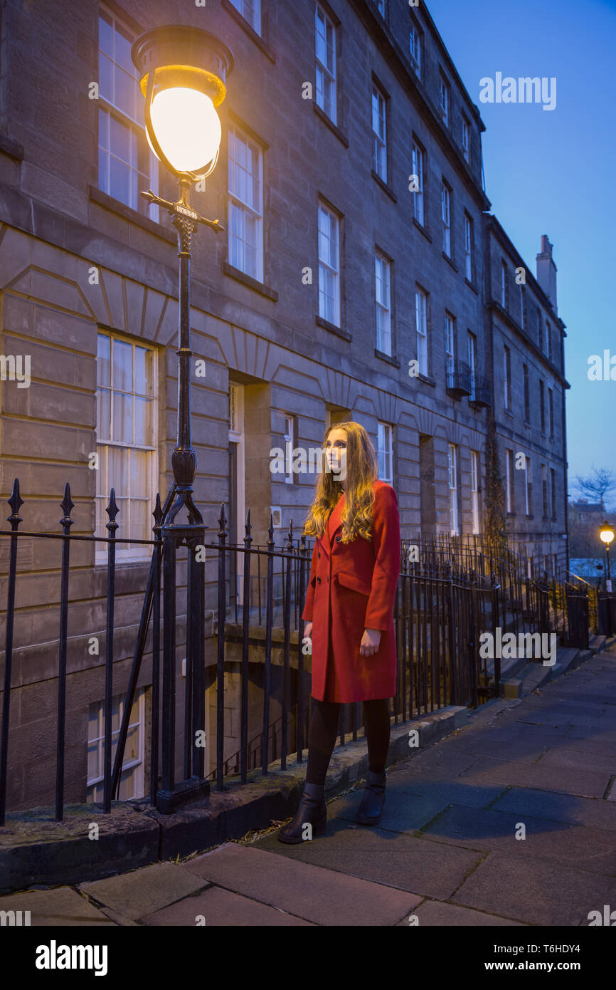 A young, attractive woman standing under a streetlight in Edinburgh. Stock Photo