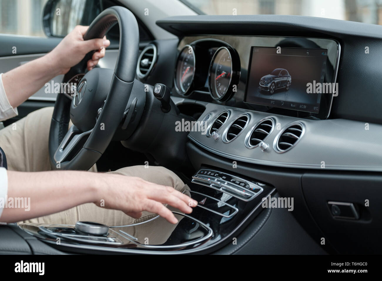 Man uses touch controls on the steering wheel Stock Photo Alamy