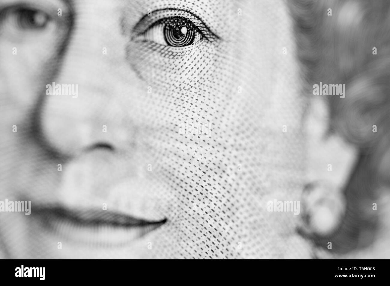 Close-up, macro photo of a piece of £10 banknote. Ten pounds sterling. Portrait of Queen Elizabeth II, eye, mouth. Stock Photo