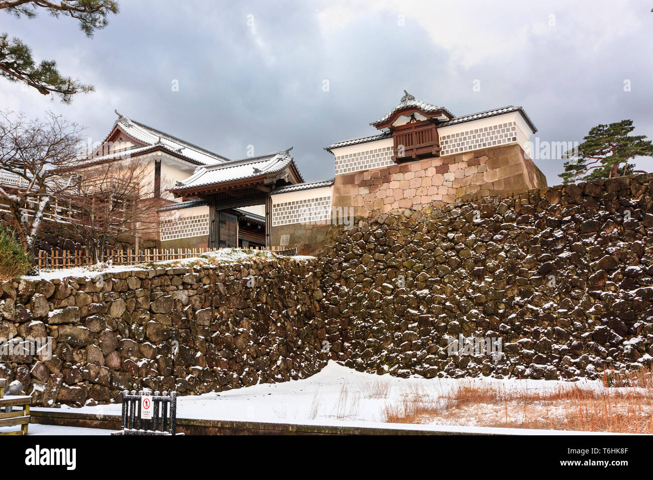 Kanazawa castle, Japan. The Koraimon type gate of the Kahoku-mon gate on top of Kahoku-zaka hill after snowfall. Dark stormy clouds overhead. Stock Photo