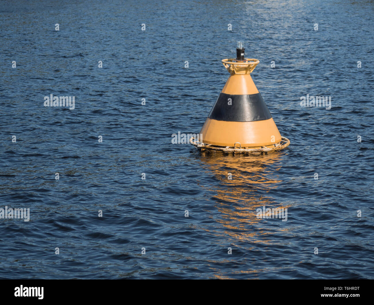 Yellow-black buoy in the water Stock Photo - Alamy