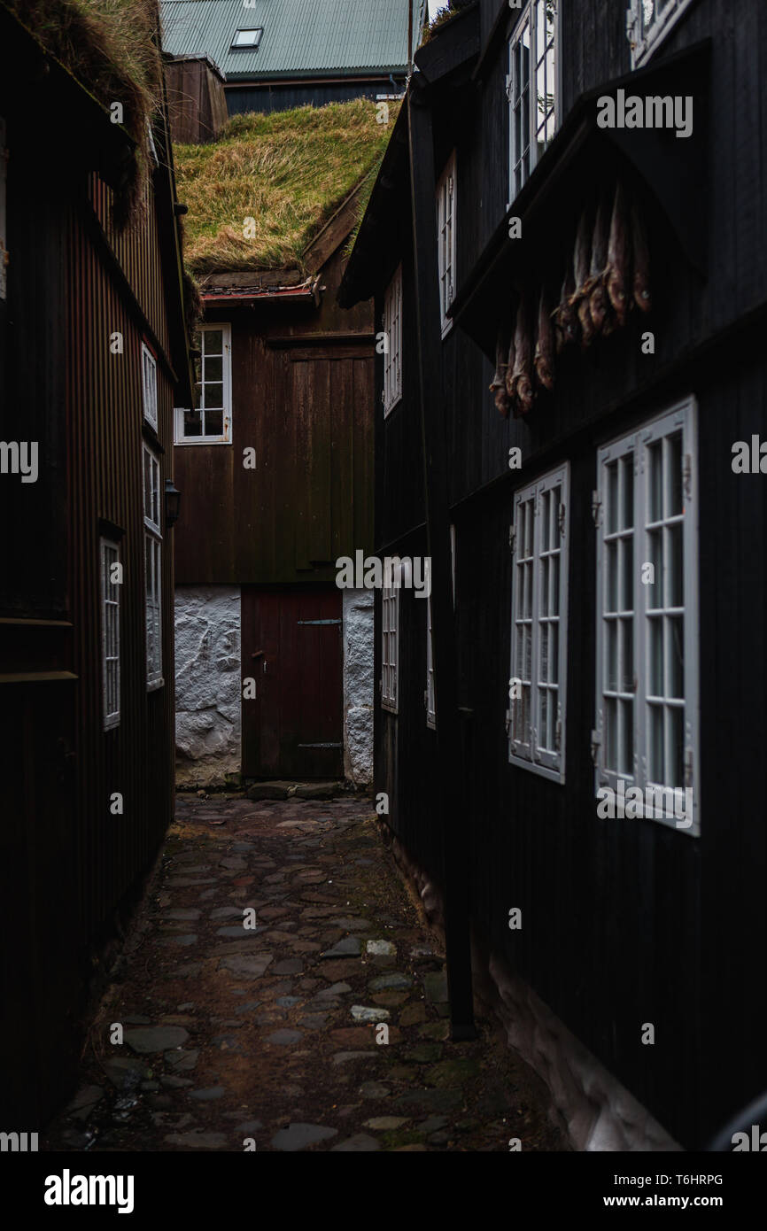Small alley in the centre of Tórshavn (capital of Faroe Islands) with typical wooden houses with moss-covered roofs and dried fish (Faroe Islands) Stock Photo