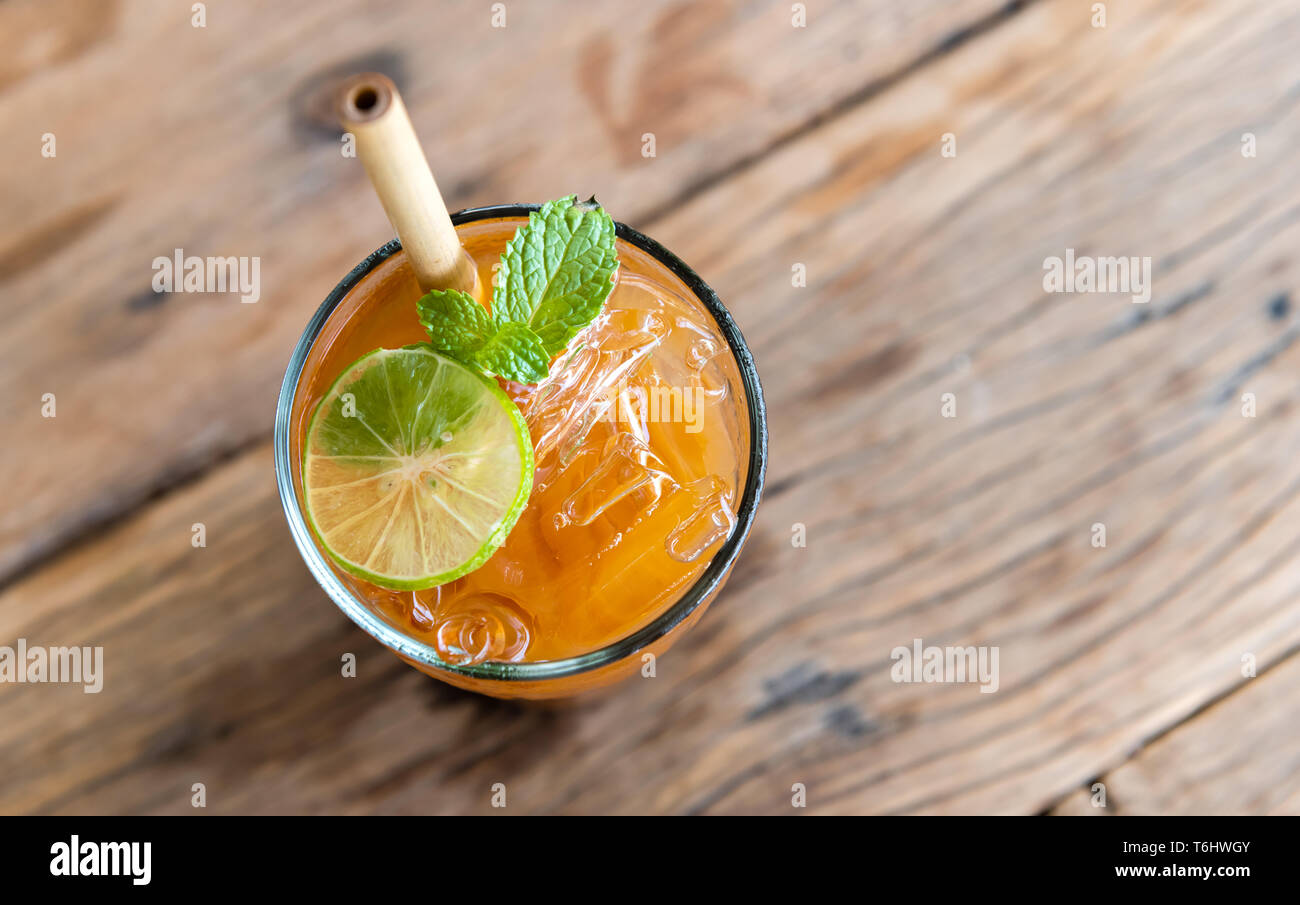 Ice cold sweet lemon tea drink  on the wooden table with outdoor sun lighting. Stock Photo
