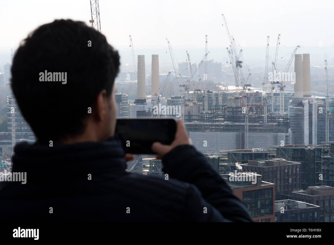 A man photographs One Nine Elms foundations under construction in Nine