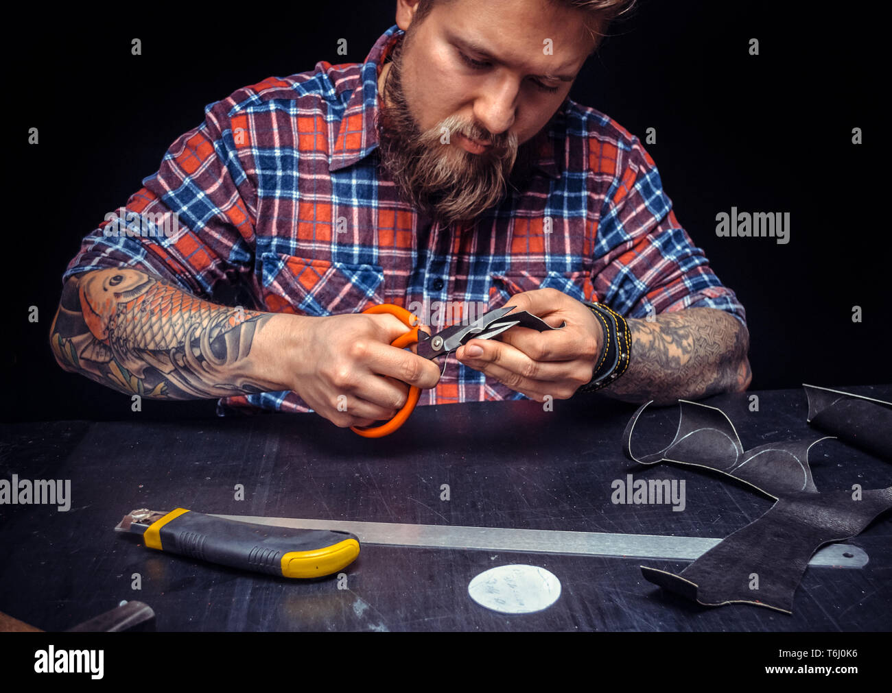 Leather Worker producing a leatherwork at leather studio Stock Photo