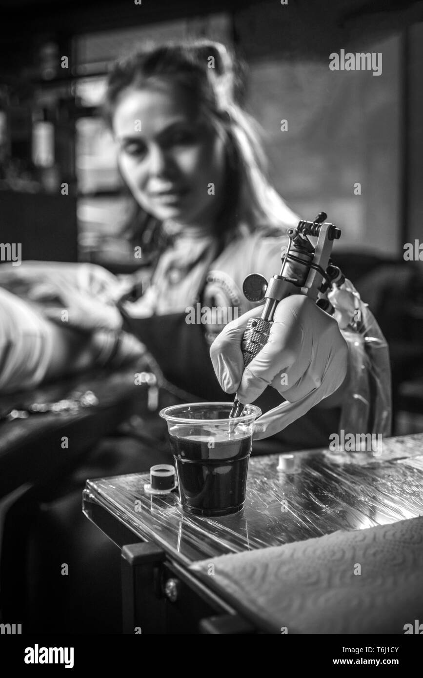 Hand of tattoo master with a tattoo gun Stock Photo - Alamy