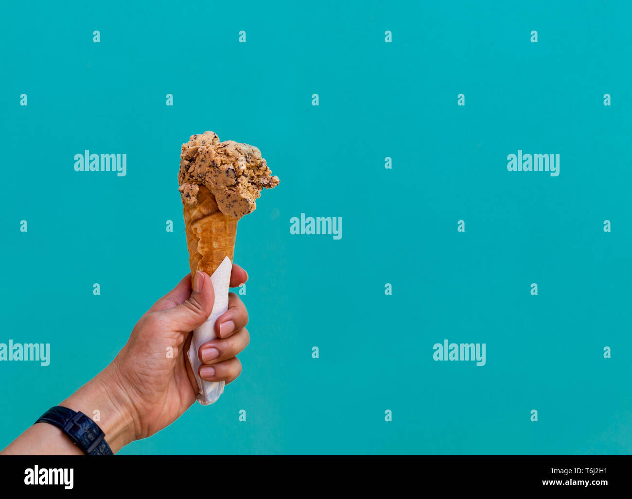 Female hand holding ice cream cone isolated on blue pastel background ...