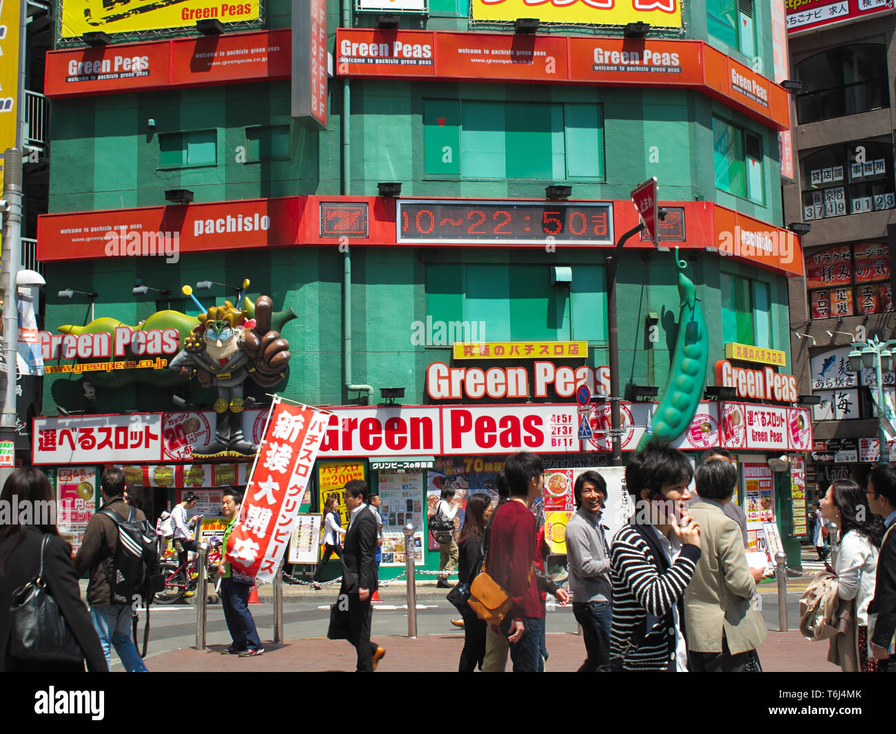 Green Peas Pachislo Pachinko and people on a plaza at Shinjuku JR station south exit, Tokyo, Honshū, Japan Stock Photo