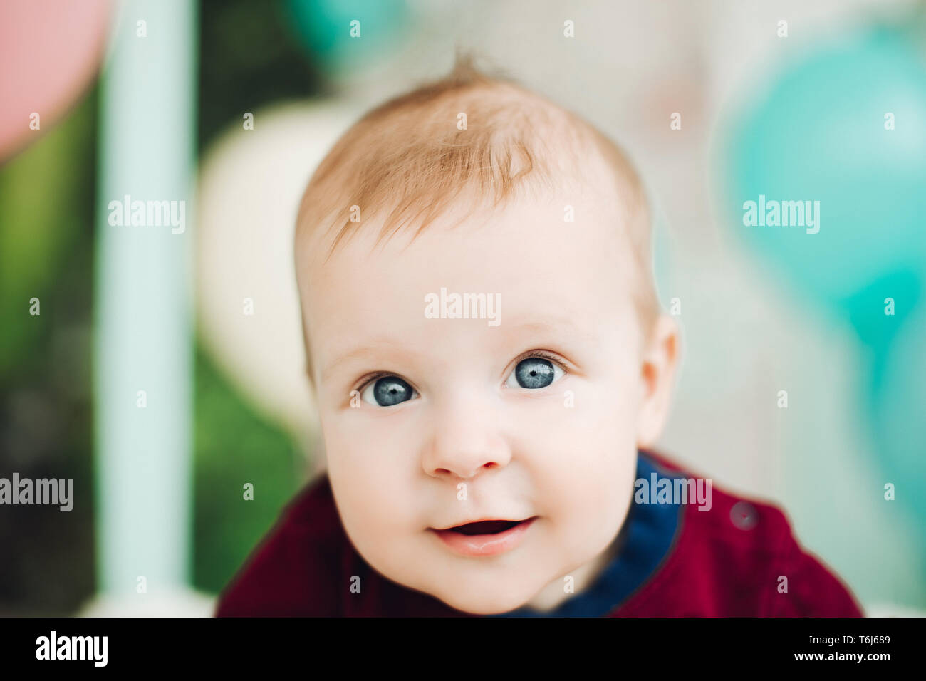 Sweet baby boy with big blue eyes lying on belly and smiling Stock