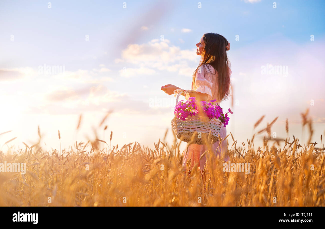 Woman in wheat field at sunset Stock Photo - Alamy