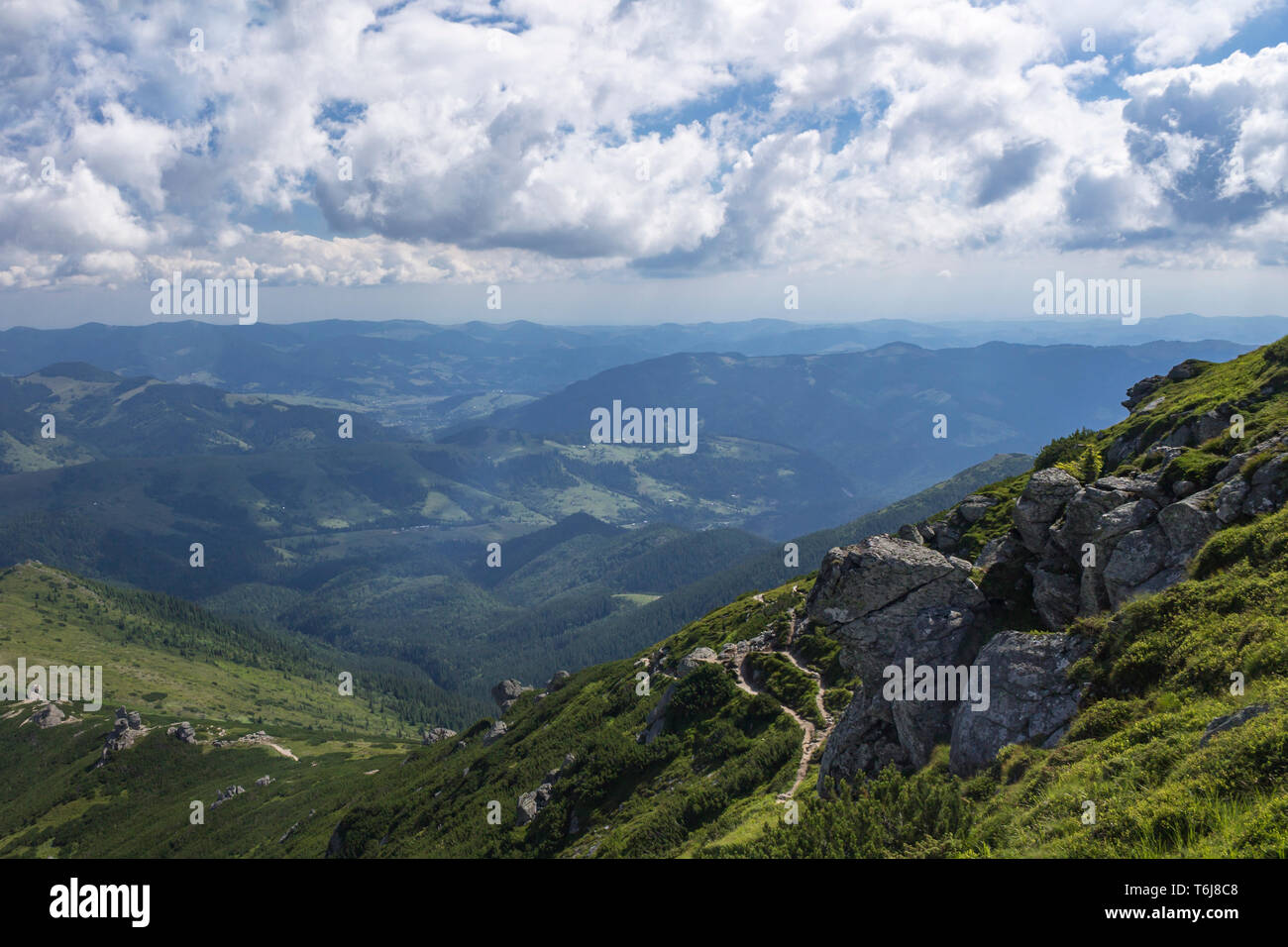 Scenic summer or spring mountain view with cloudy sky. Ukraine, Carpathians, Dzembronia High mountains in vivid color. Nobody. Beautiful mountain lanscape or valley. Stock Photo