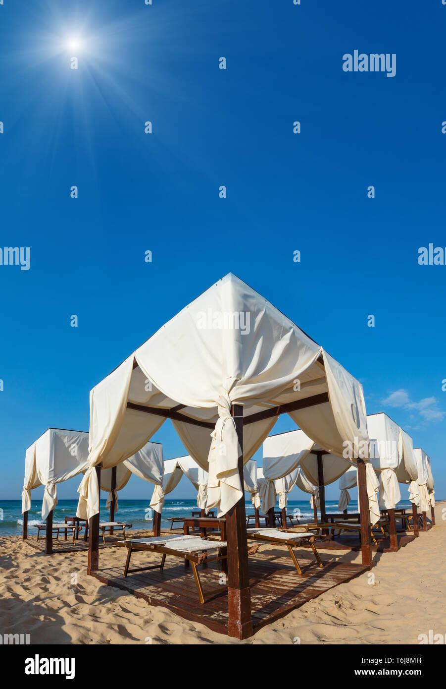 Beach canopies on white sandy beach Stock Photo