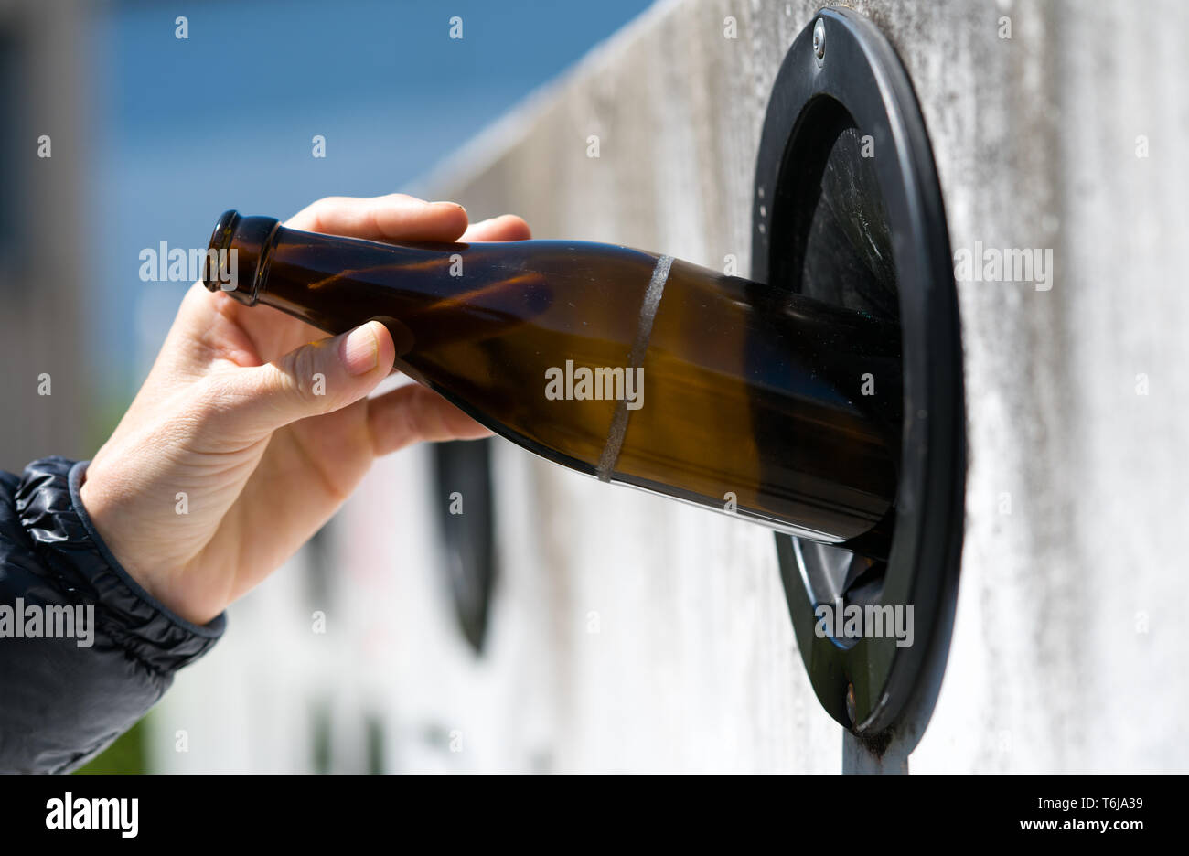 detail view of a female hand recycling glass to save the environment at
