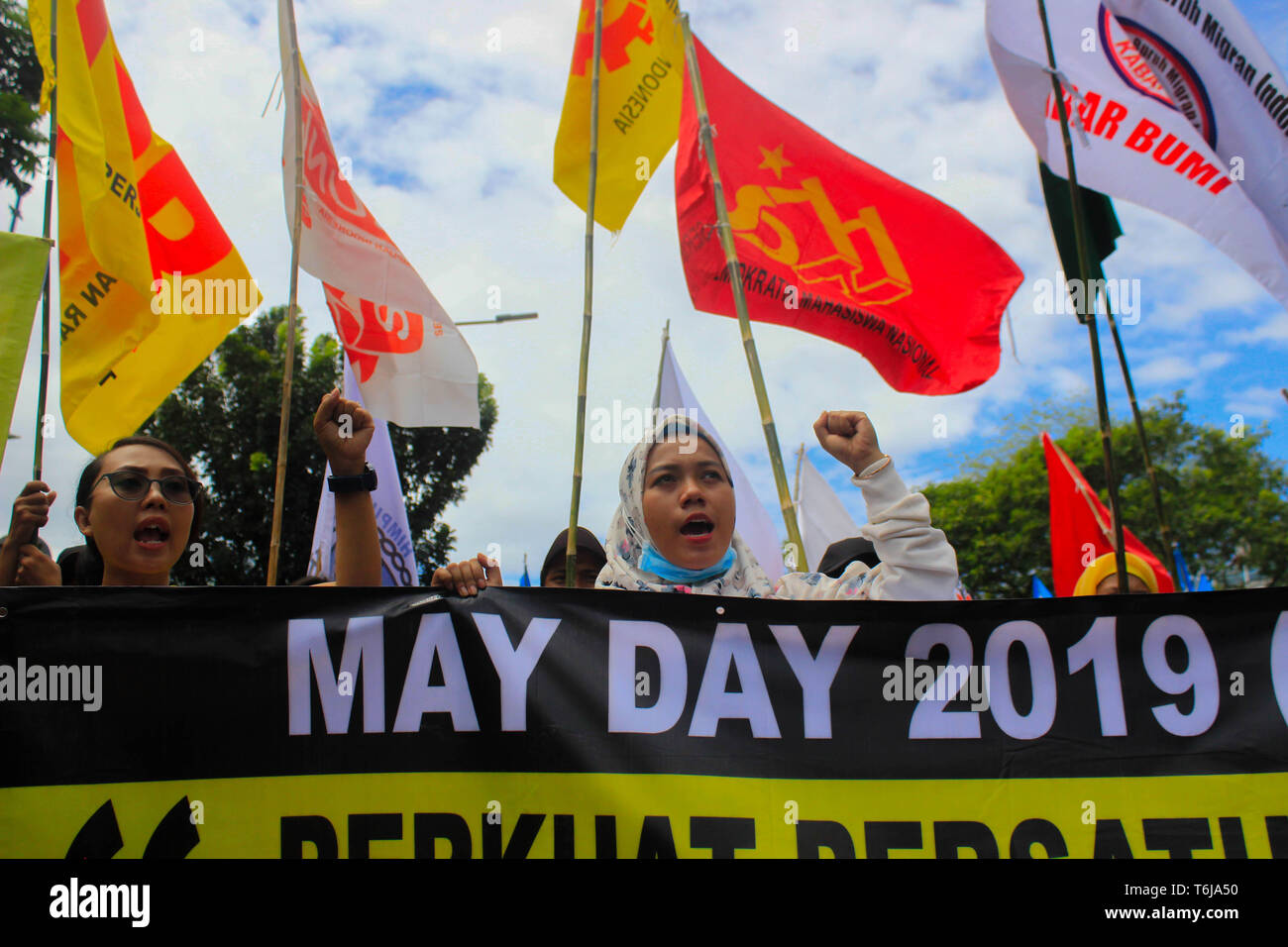 Workers are seen shouting slogans while holding flags and a banner during the rally. Thousands of workers are urging the government to raise minimum wages and to improve working conditions. Stock Photo