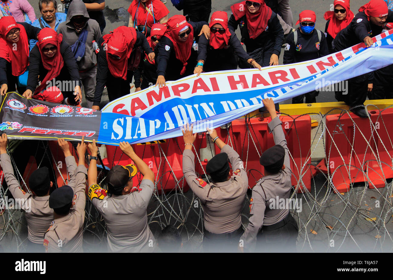 Workers are seen holding a banner during the rally. Thousands of workers are urging the government to raise minimum wages and to improve working conditions. Stock Photo