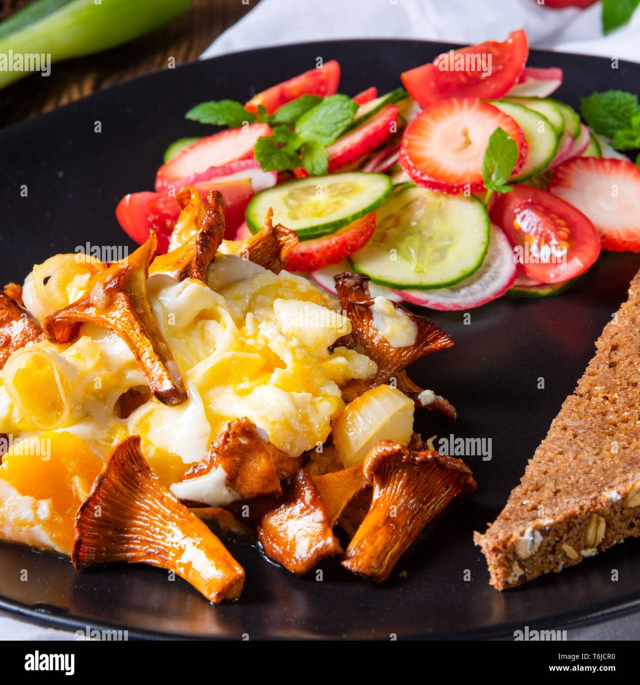 fresh chanterelles with scrambled eggs and a green salad Stock Photo