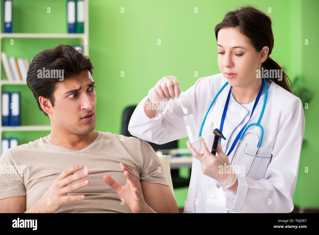 Female doctor checking patient's ear during medical examination Stock