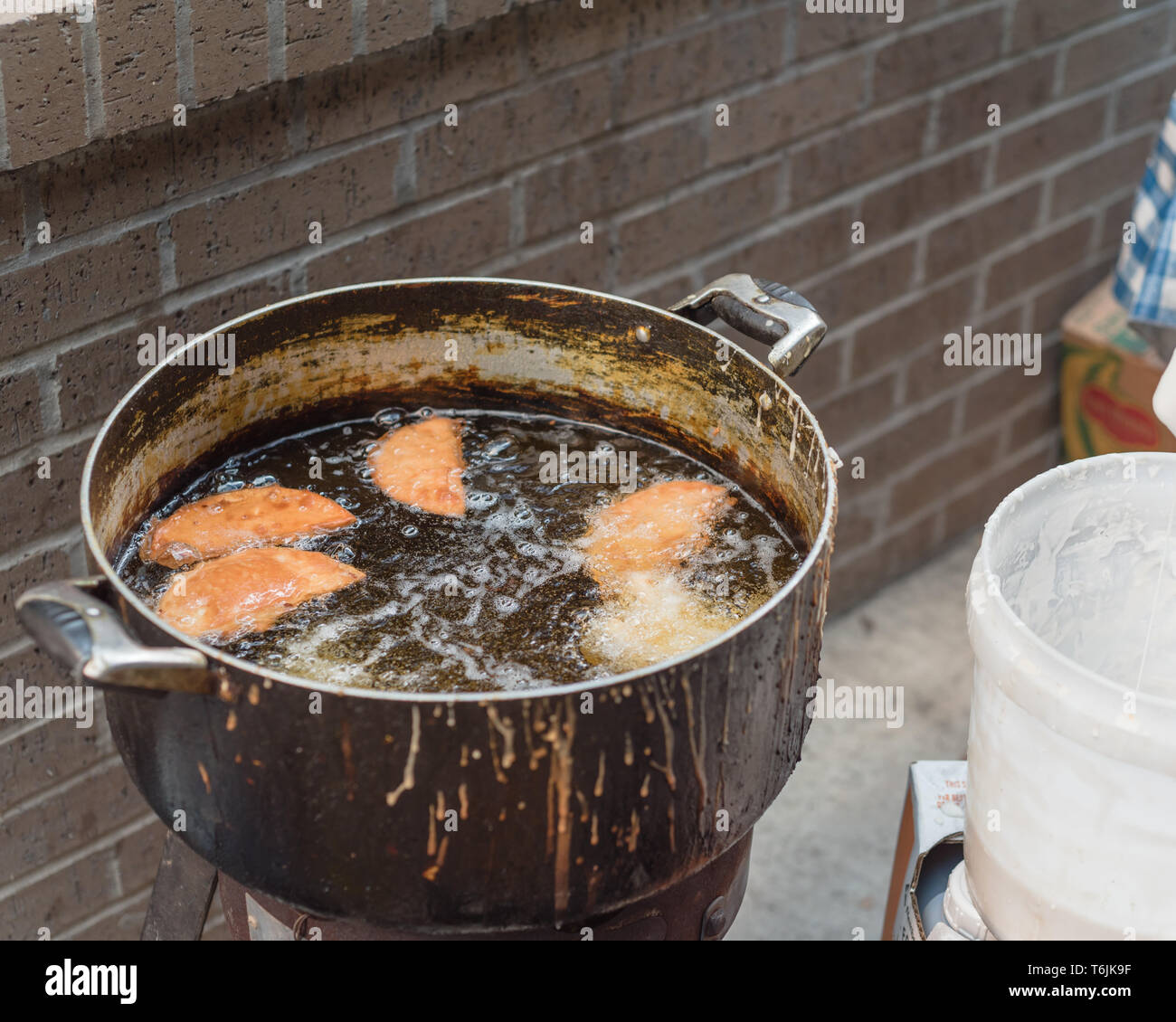 Deep fried rice flour cakes in hot and flaming oil pot at street food