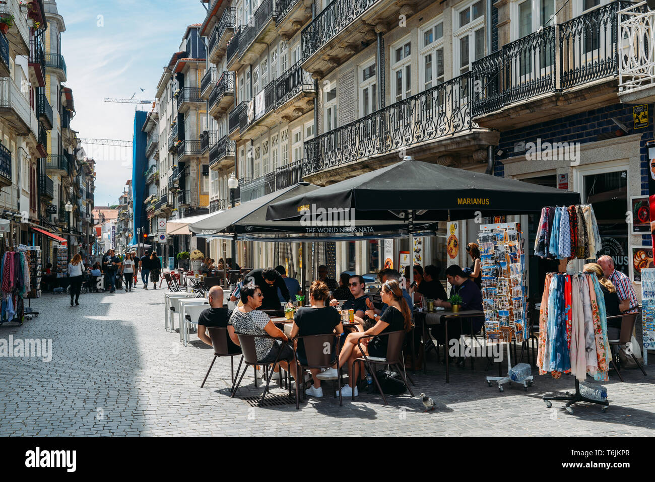 Porto, Portugal - April 29, 2019: People sit at cafe terraces on a sunny afternoon in the historic centre of Porto - UNESCO World Heritage Site Stock Photo